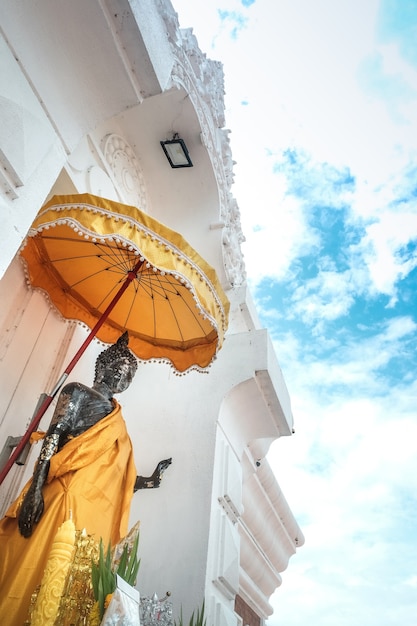 Antykwarska trwanie Tajlandzka Buddha statua i niebieskie niebo