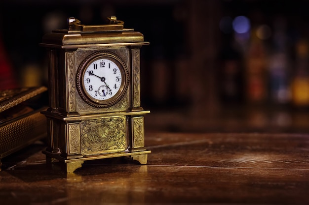 Zdjęcie antykwarski zegarowy stojak na drewnianym stole