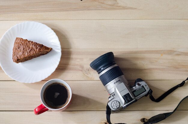 Zdjęcie aparat fotograficzny na drewnianym tle kawa i ciasto