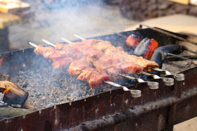 Apetyczny szaszłyk pieczony z dymem na szaszłykach na grillu na węgiel drzewny na świeżym powietrzu