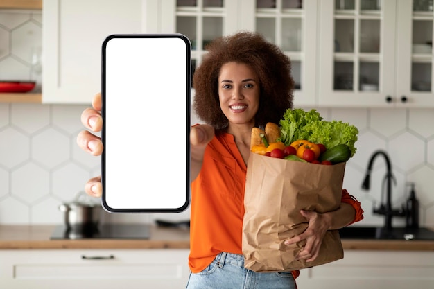 Aplikacja Dostawy Spożywczej Czarna Kobieta Pokazuje Pusty Smartphone I Torbę Z Zakupami
