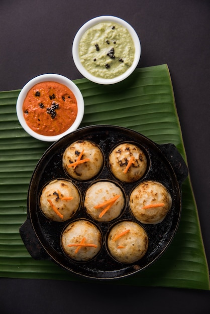 Appam lub Mixed dal lub Rava Appe podawane na nastrojowym tle z zielonym i czerwonym sosem chutney. Kula w kształcie popularnej południowoindyjskiej receptury śniadaniowej. Selektywne skupienie