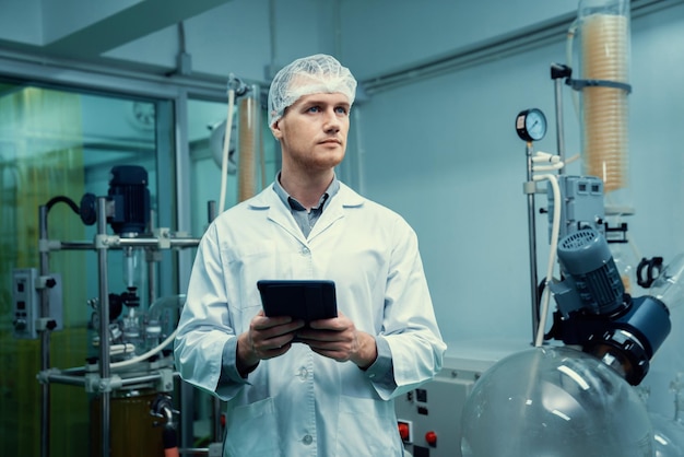 Aptekarz pracujący w laboratorium do ekstrakcji konopi za pomocą tabletu