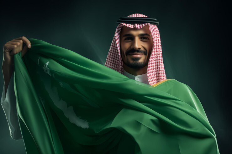 Arab Saudyjski trzyma flagę Arabii Saudyjskiej i świętuje Święto Narodowe