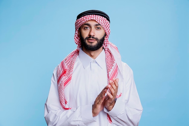 Arab w thobe i ghutra aplauduje