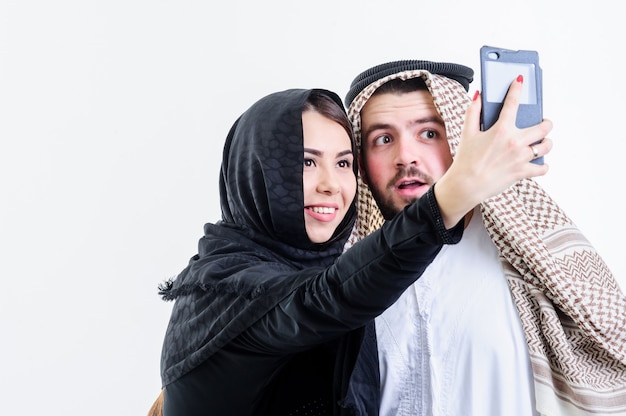 Arabska para robi sobie zdjęcia ze sprzedażą telefonu. Selfie.