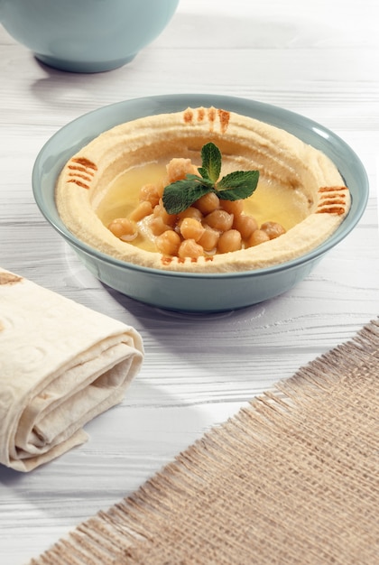 Arabski Hummus, Chlebowa Rolka I Hessian Workowy Tekstylny Na Drewnianym Stole