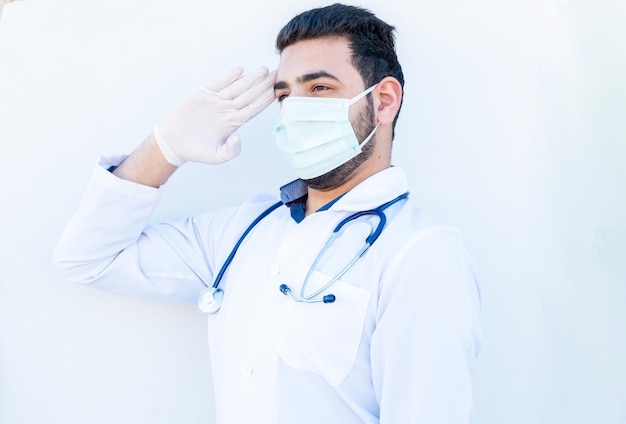 Arabski lekarz wykonujący salut wojskowy z maską na twarzy