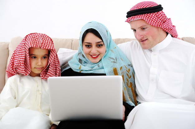 Arabski rodziców i mały chłopiec w domu z komputera przenośnego