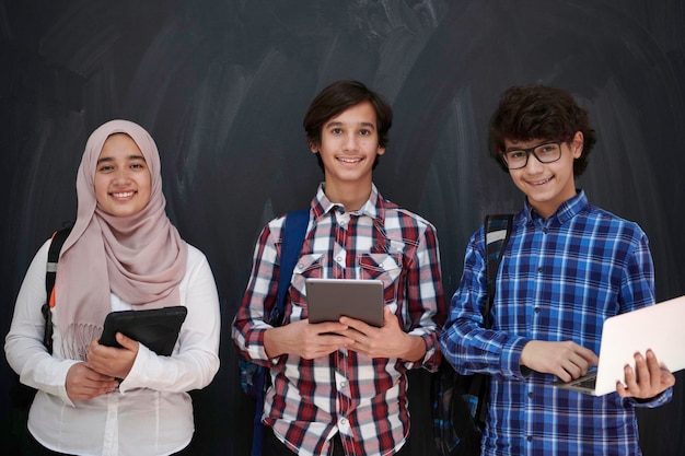 Arabski zespół nastolatków, grupa studentów pracująca razem na laptopie i tablecie koncepcja edukacji online w klasie