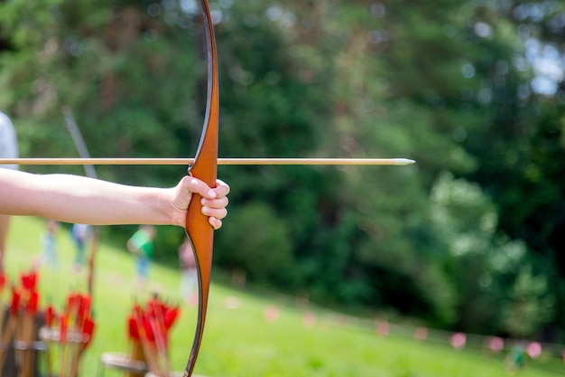 Archer trzyma swój łuk, celując w docelową aktywność na świeżym powietrzu.