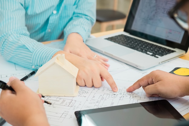 Architekt lub planista pracuje na rysunkach dla planów budowy przy stole