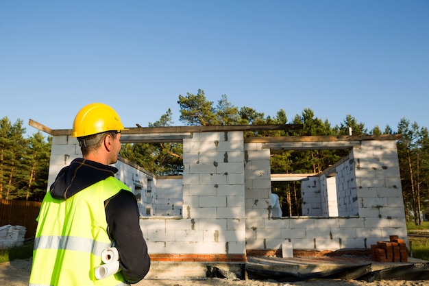 Architekt projektu stoi przy budowie domu ze ścianą