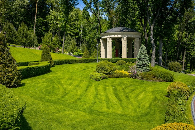 Architektura krajobrazu w ogrodzie Ścieżka w ogrodziePiękny projekt krajobrazu podwórkowegoKilka kwiatów i ładnie przycięte krzewy na wyrównanym podwórkuFormalny krajobraz