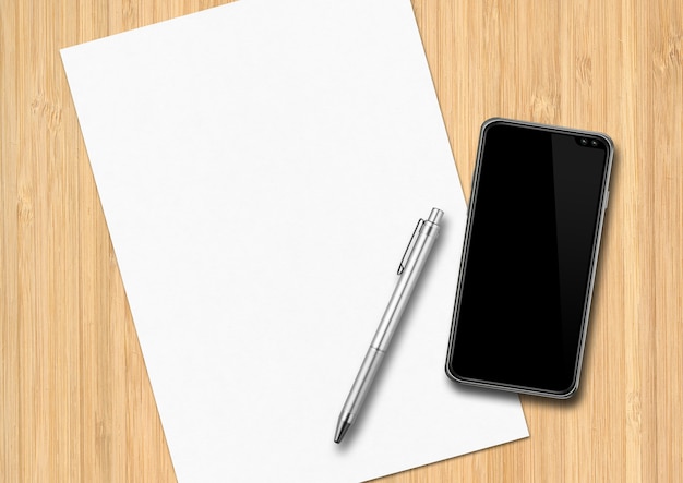 Arkusz papieru, długopis i smartfon na drewnianym biurku