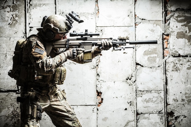 Army Ranger poruszający się wzdłuż betonowej ściany podczas misji