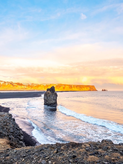 Arnardrangur na wybrzeżu w pobliżu łuku Dyrholaey otaczającego ciężką falę i góry Islandia