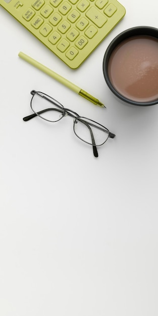 Artykuły biurowe nad biurkiem z klawiaturą i okularami i filiżanką kawy do zdalnej pracy różne narzędzia szkolne do nauki z gorącym napojem i okularami