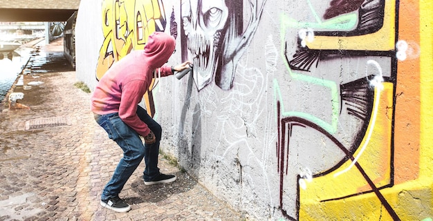 Artysta uliczny malujący kolorowe graffiti na ścianie publicznej