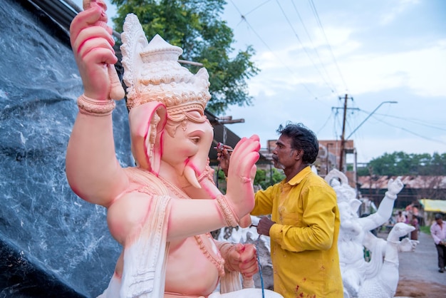 Artysta Wykonujący Rzeźbę I Wykańczający Figurkę Hinduskiego Boga Pana Ganesha W Warsztacie Artysty Na Festiwal Ganesha