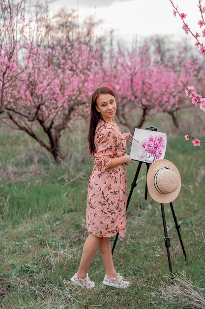 Zdjęcie artystka maluje sad brzoskwiniowy w sadzie brzoskwiniowym wiosna