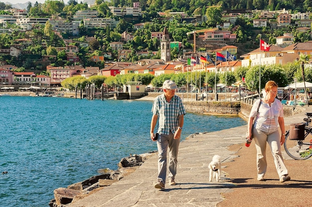 Ascona, Szwajcaria - 23 sierpnia 2016: Ludzie przechodzący przy promenadzie w luksusowym kurorcie w Ascona nad jeziorem Maggiore w kantonie Ticino w Szwajcarii.