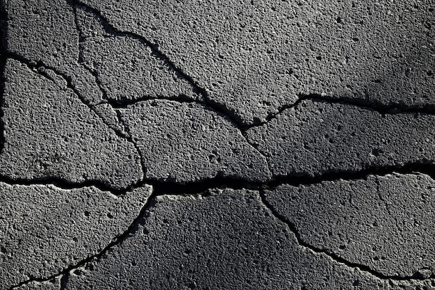 asfalt w pęknięciach tekstura / abstrakcyjne tło pęknięcia na asfaltowej drodze