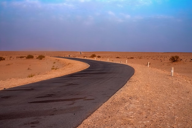 Asfaltowa droga biegnąca wzdłuż pustyni sahara pustynia sahara tunezja