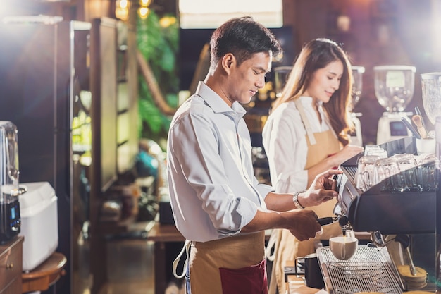 Asian Barista przygotowujący filiżankę kawy, espresso z latte lub cappuccino