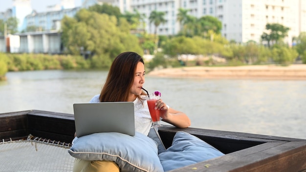 Asian businesswoman pracy online na plaży. Freelancer wykorzystujący technologię do pracy wszędzie. Nowy normalny styl życia po Covid-19.