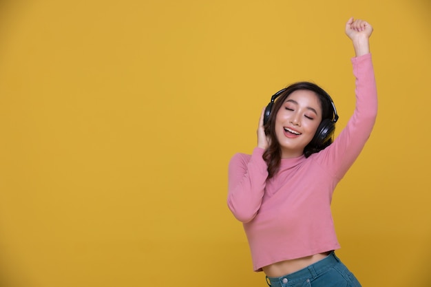 Asian kobieta noszenie słuchawek bezprzewodowych, ciesząc się słuchaniem muzyki