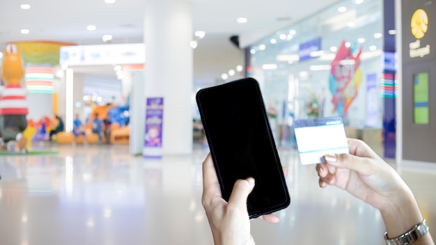asian kobieta za pomocą inteligentnego telefonu i karty kredytowej zakupy online