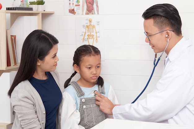 Asian man doctor mówi do dziecka i matki Zapobieganie i koncepcji opieki zdrowotnej