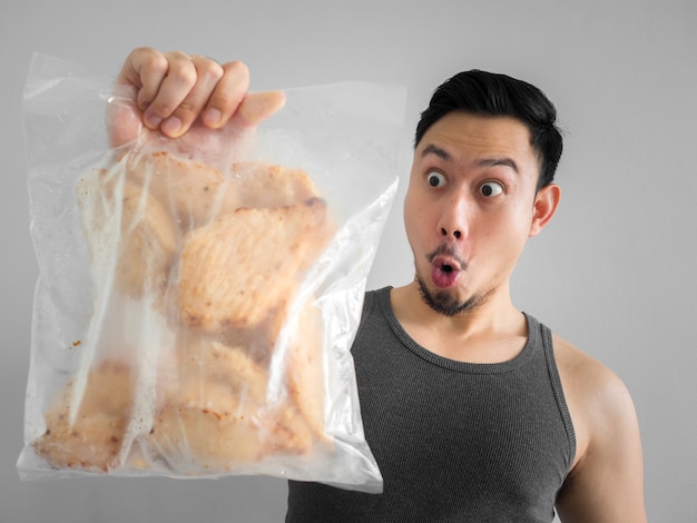 Asian man show pierś z kurczaka czysty protien dobry początek diety dla zdrowego życia.