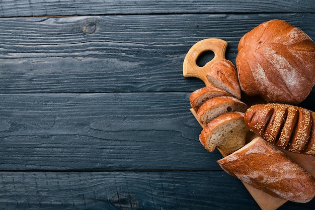 Zdjęcie asortyment chleba i pieczenia na drewnianym tle widok z góry wolne miejsce na tekst