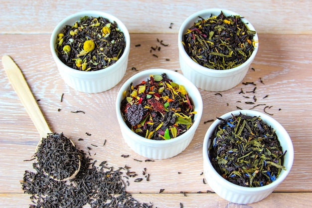 Asortyment herbaty Różne rodzaje herbaty w białej misce na drewnianym rustykalnym tle
