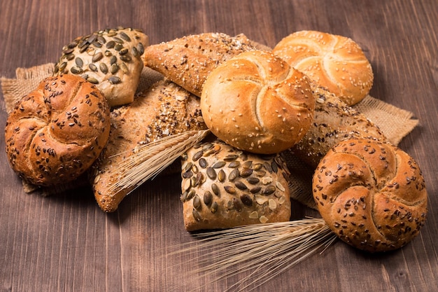 Asortyment pieczonego chleba z nasionami na tle drewniany stół. Piekarnia. Koncepcja bezpieczeństwa żywności.