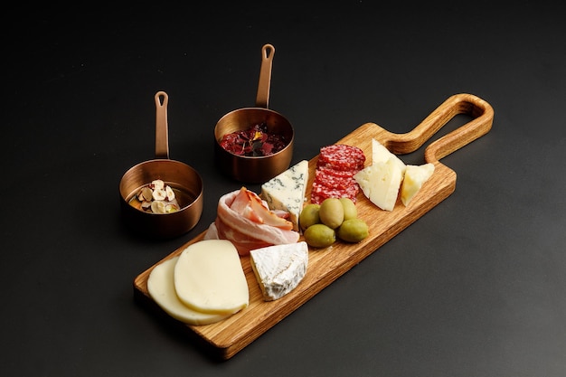 Zdjęcie asortyment różnych rodzajów serów i wędlin podawany z sosami deska serów