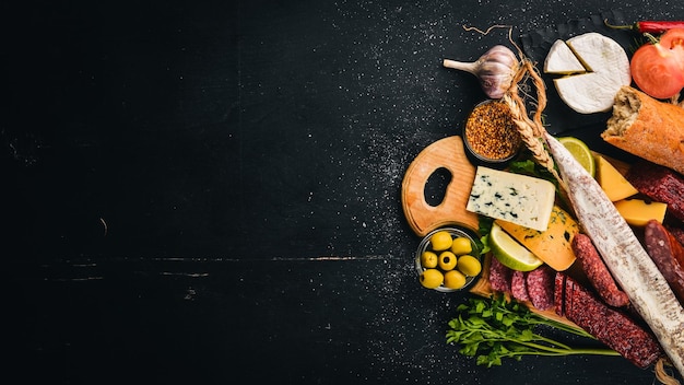 Asortyment serów i tradycyjnych kiełbasek na drewnianym tle Brie cheese blue cheese gorgonzola fuete salami Wolne miejsce na tekst Widok z góry