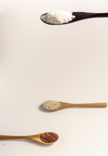 Asortyment surowego i niegotowanego ryżu w drewnianą łyżką na białym tle Miejsce na tekst Widok z góry