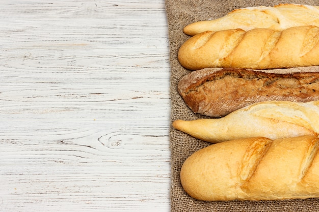 Asortyment świezi Francuscy baguettes na drewnianym stołowym tle