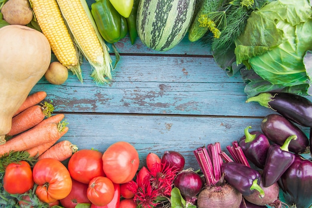 Asortyment świeżych organicznych warzyw na niebieskim drewnianym tle