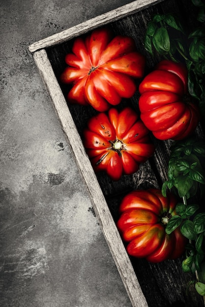 Zdjęcie asortyment świeżych warzyw i ziół pomidory bazylia na stole
