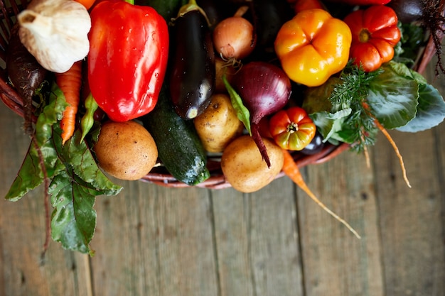 Asortyment świeżych warzyw w koszu, bio zdrowej, ekologicznej żywności na drewniane tła, styl rynku wiejskiego, produkty ogrodowe, dieta wegetariańska, czyste jedzenie.