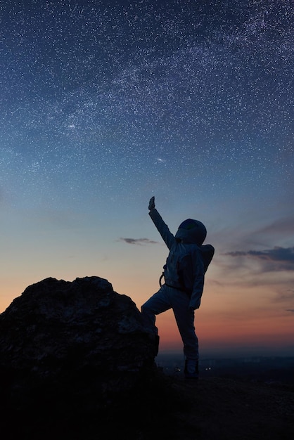 Astronauta stojący pod pięknym nocnym niebem