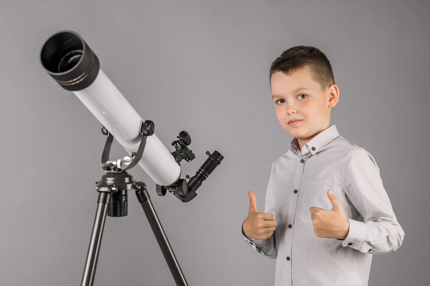Astronom młody chłopak patrząc przez teleskop.