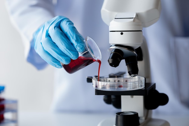 Asystent laboratoryjny naukowiec medyczny badacz chemii trzyma szklaną rurkę przez próbkę krwi przeprowadza eksperyment chemiczny i bada próbkę krwi pacjenta Koncepcja medycyny i badań