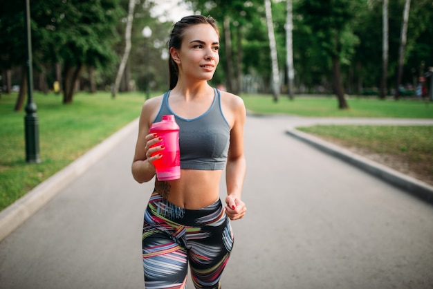 Athletic dziewczyna z butelką sport w lato park