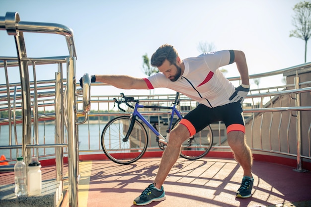 Athletic mężczyzna w odzieży sportowej, rozciągający się na ulicy