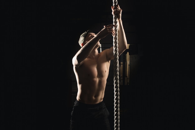 Atleta robi sprawności fizycznej arkany wspinaczce ćwiczy w sprawności fizycznej gym treningu